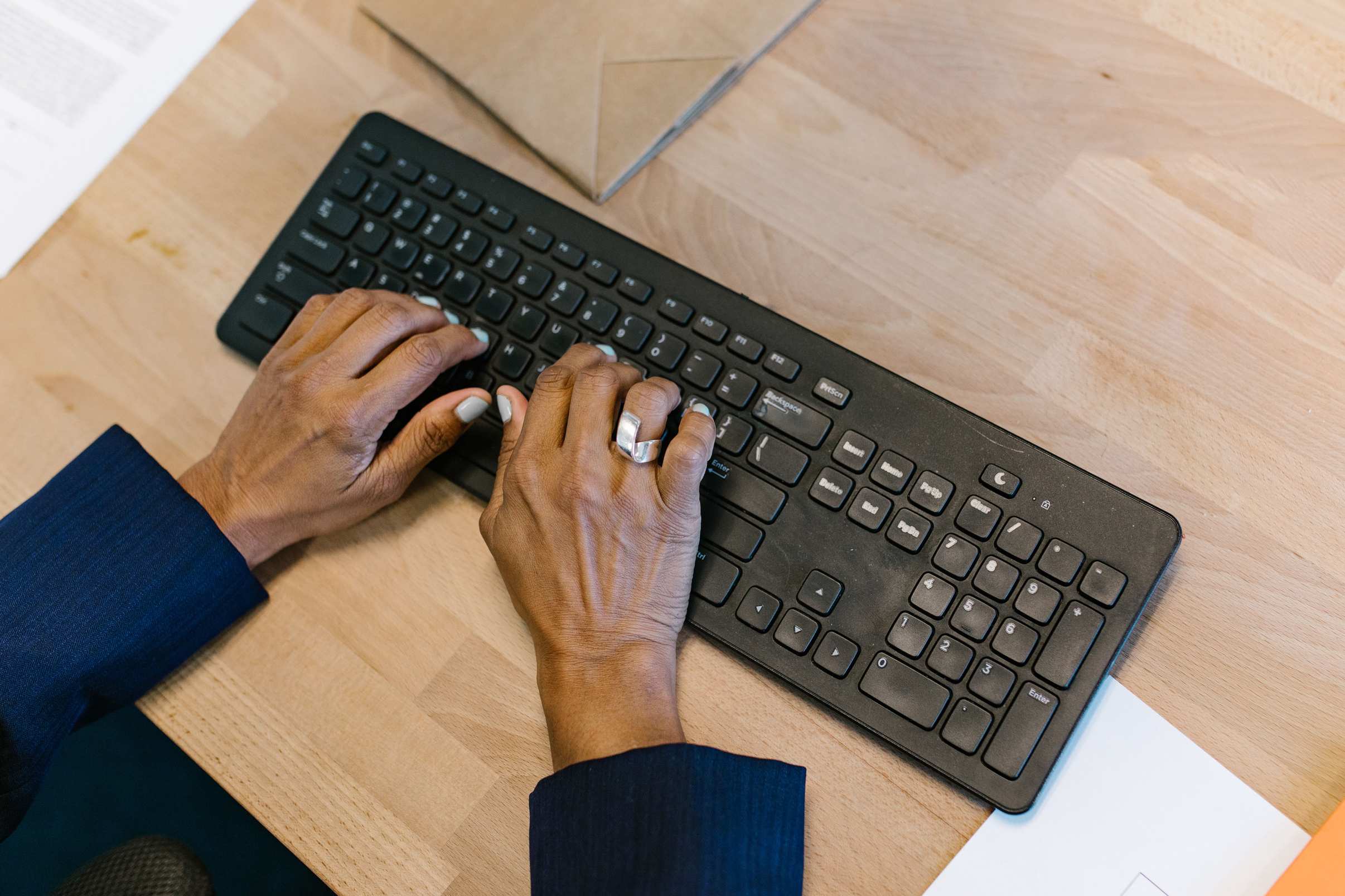 Hands typing on a keyboard during a focused work session in an office